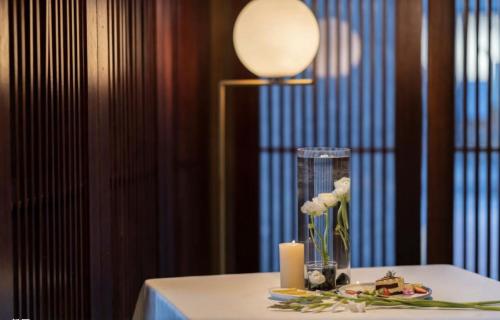 a table with a candle and flowers in a vase at Hong Long Jing Hotel in Dali