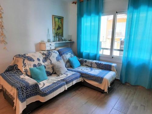 - un salon avec un canapé et des rideaux bleus dans l'établissement Apartamento Llançà, 3 dormitorios, 6 personas - ES-170-84, à Llançà