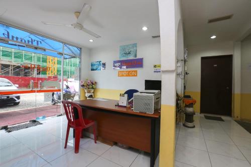 un bureau avec un bureau et une chaise rouge dans l'établissement OYO 89925 Innap Kota Bharu, à Kota Bharu