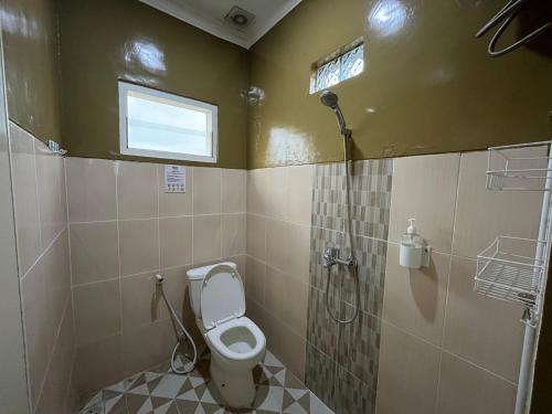 a bathroom with a toilet and a shower at Omah Belimbing RedPartner near ABM Malang in Blimbing