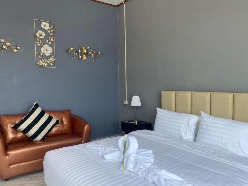 a bedroom with a bed and a leather chair at Tulip Hotel in Louang Namtha