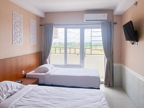 duas camas num quarto de hotel com uma janela em Skyview Setiabudi Apartment Medan Redpartner em Sunggal