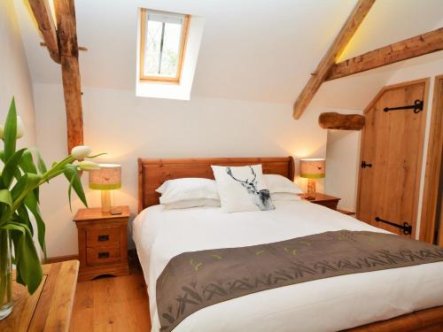 a bedroom with a large bed with two lamps at 3 bed in Bickleigh HOBAR in Thorverton