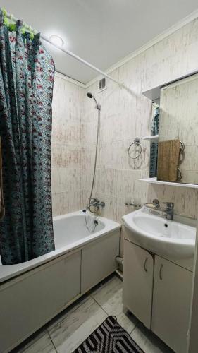 a bathroom with a tub and a sink and a shower at Люкс трёхкомнатная квартира ТРЦ Галактика Уральск in Oral