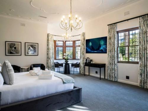 a bedroom with a large bed and a chandelier at Palm House Boutique Hotel in Cape Town