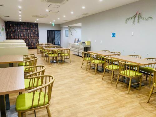 ein Zimmer mit Tischen und Stühlen in einem Zimmer in der Unterkunft ホリディパールホテル in Osaka