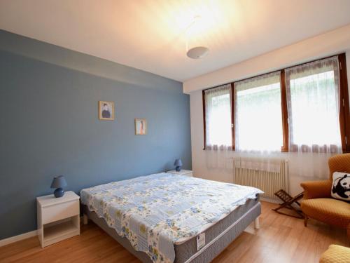 - une chambre bleue avec un lit et une chaise dans l'établissement Appartement Évian-les-Bains, 3 pièces, 4 personnes - FR-1-498-96, à Évian-les-Bains
