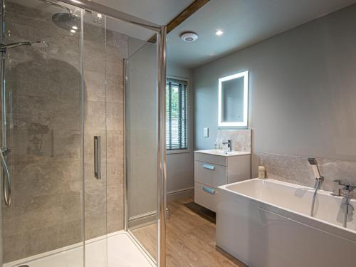 a bathroom with a shower and a tub and a sink at 4 bed in Monmouth 83768 in Saint Weonards