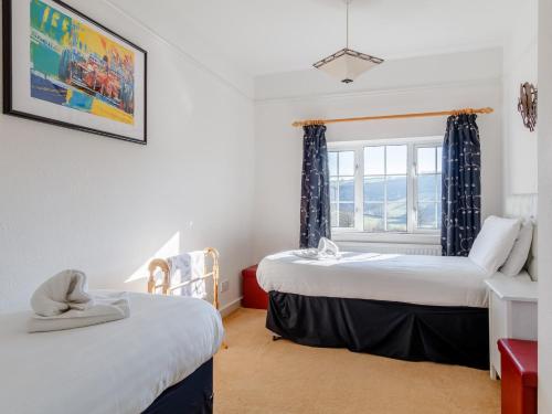 two beds in a room with a window at 7 bed in Exford MONKH in Exford