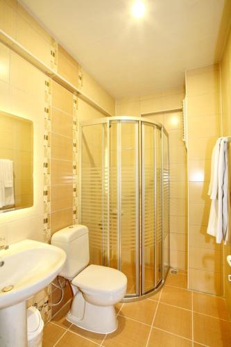 a bathroom with a toilet and a sink and a shower at Magi Apart Hotel in Alanya