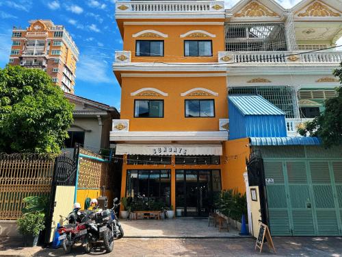 プノンペンにあるSundays Boutique Eco Hotelの建物の前に駐車されたバイク