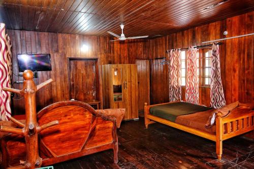 1 dormitorio con 2 camas y paredes de madera en Hill Valley Farm House, en Nelliyampathy