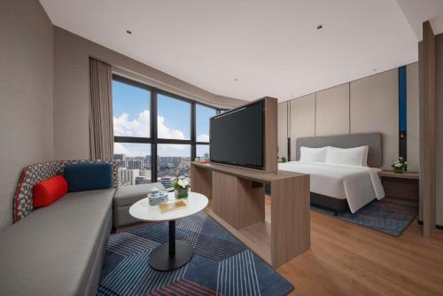a hotel room with a bed and a television at Holiday Inn Express Shantou Chenghai in Shantou