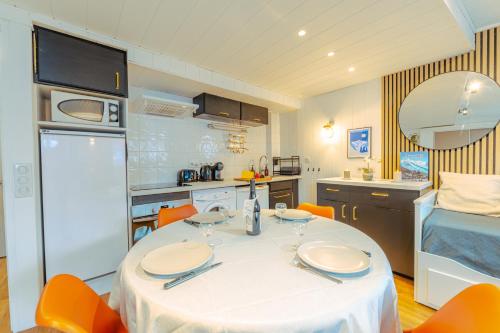 - une cuisine avec une table blanche et des chaises orange dans l'établissement Studio De La Marmotte - Happy Rentals, à Chamonix-Mont-Blanc