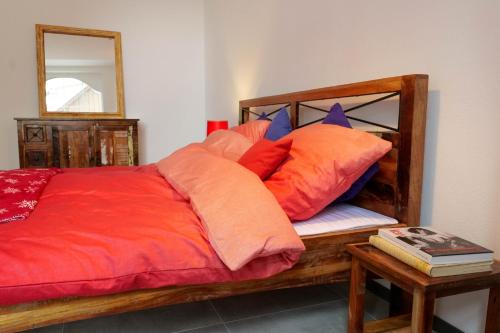 a bed with orange and blue pillows and a mirror at Goldener Löwe in Bodman-Ludwigshafen