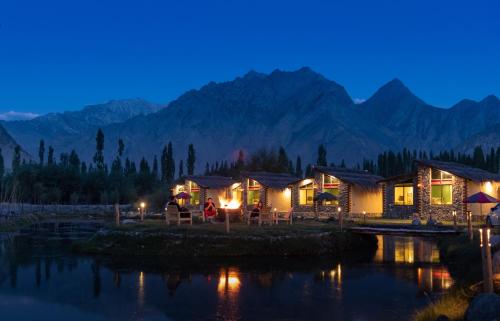a row of lodges with mountains in the background at night at LOKAL Rooms x Skardu (Katpana Retreat) in Skardu