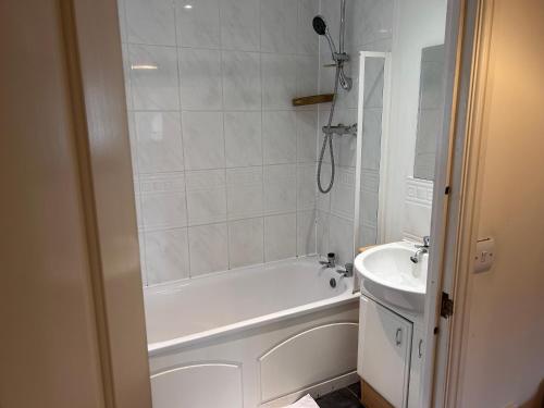a white bathroom with a tub and a sink at Best in Purfleet