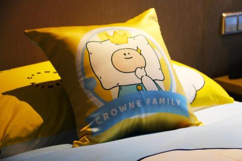 a pillow with a cartoon character on it on a bed at Crowne Plaza Yibin by IHG in Yibin