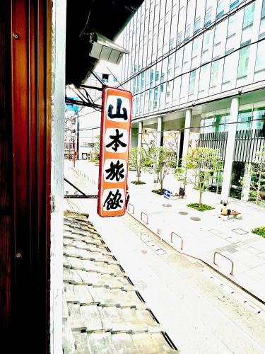 a sign on the side of a building with asian writing on it at Yamamoto Ryokan in Fukuoka