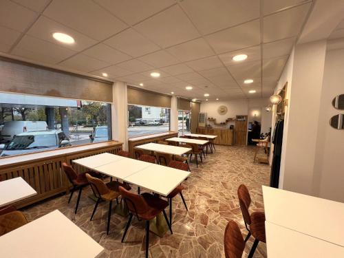 eine Reihe von Tischen und Stühlen in einem Restaurant in der Unterkunft Contact Hôtel Foch in Besançon