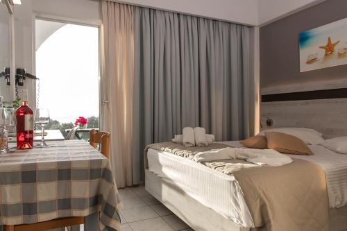 a bedroom with a bed and a table and a window at Irene Studios in Mastichari