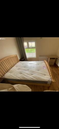 a large bed in a room with a window at Patrick’s house in Athlone