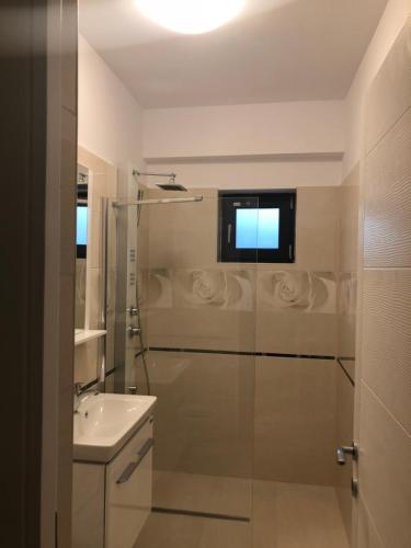 uma casa de banho com um chuveiro e um lavatório. em Apartament cu 3 camere Rovine em Craiova