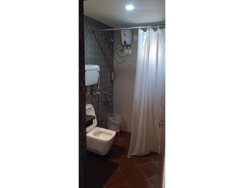 La salle de bains est pourvue d'une douche et de toilettes. dans l'établissement Shubham Resorts, Solapur, à Solapur