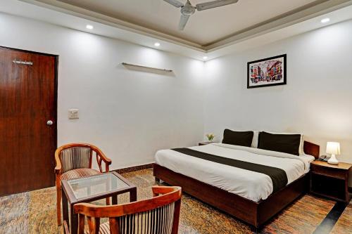 a bedroom with a bed and a table and a chair at Hotel VM Residency in New Delhi