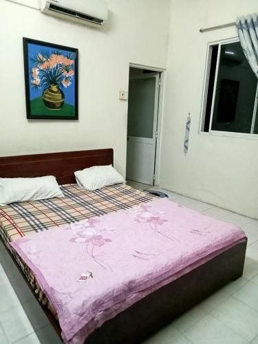 een slaapkamer met een groot bed en een roze deken bij Nhà nghỉ mình Hoàng in Xã Thắng Nhí (1)