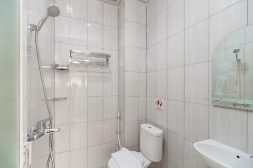 a white bathroom with a toilet and a sink at RedDoorz at Homestay Lotus 2 Pangkal Pinang in Pangkal Pinang