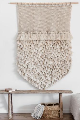 a woven curtain hanging on a wall next to a bench at Oceanview Kiama Luxury Holiday Accommodation in Kiama