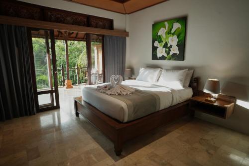 1 dormitorio con 1 cama grande y balcón en New Mumbul Ubud en Ubud