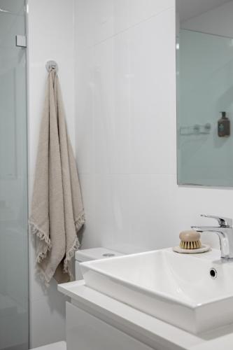 a white bathroom with a sink and a mirror at Oceanview Kiama Luxury Holiday Accommodation in Kiama