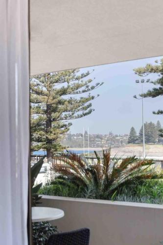 a room with a window with a view of a beach at Oceanview Kiama Luxury Holiday Accommodation in Kiama
