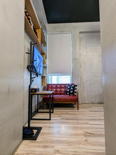 a living room with a red couch and a tv at 40Inn Backpackers Warehouse in Taitung City