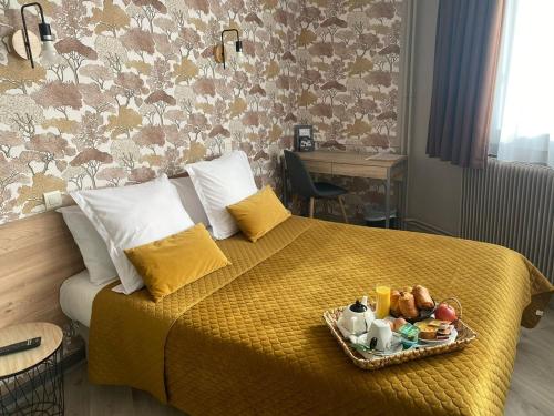 a hotel room with a bed with a tray of food on it at Contact Hôtel Foch in Besançon