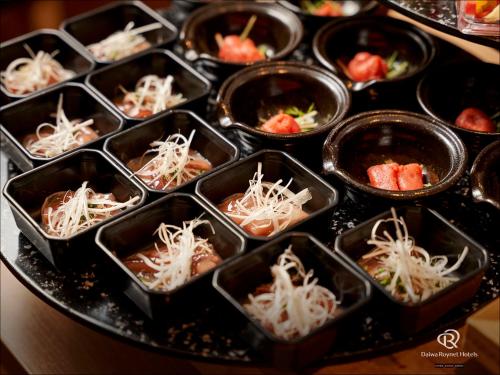 a bunch of containers of food on a table at Daiwa Roynet Hotel Takamatsu in Takamatsu