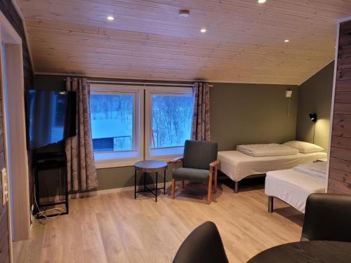 a room with two beds and a flat screen tv at Lapphaugen Turiststasjon in Tennevoll