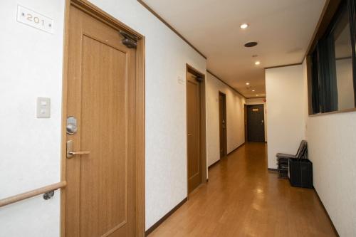un pasillo vacío con una puerta de madera y un pasillo sidx sidx en La-se-ri Resort & Stay - Vacation STAY 63368v, en Himi
