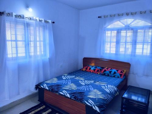 1 dormitorio con 1 cama y 2 ventanas en Beach ColvaPearl Luxury 3 BHK Villa, en Colva