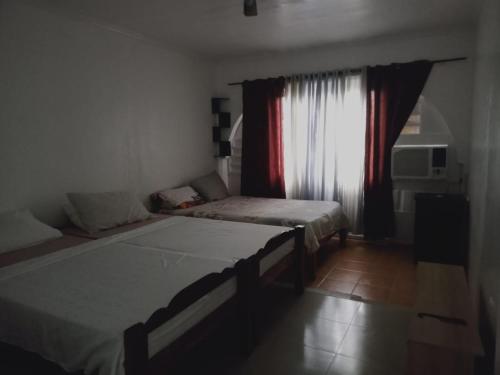 a bedroom with two beds and a window at SEASCAPE in Moalboal