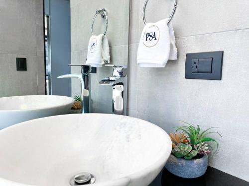 a bathroom with a white sink and two white towels at Puerto Santa Ana Luxury Suites Guayaquil in Guayaquil