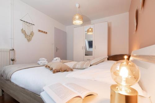 - une chambre avec un lit avec un livre et une lampe dans l'établissement La Loge by 