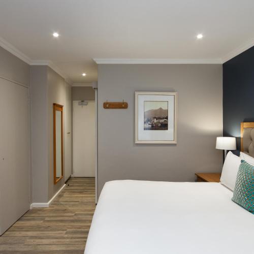 a bedroom with a white bed and a picture on the wall at Premier Express Inn George in George