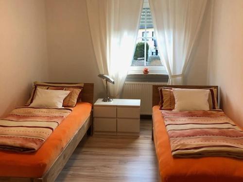 two beds in a room with a window at Ferienwohnung Weinberg in Markt Einersheim