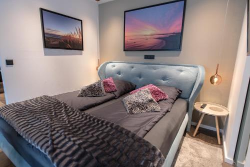 1 dormitorio con 1 cama azul y 2 almohadas en Ocean House Glück, en Timmendorfer Strand