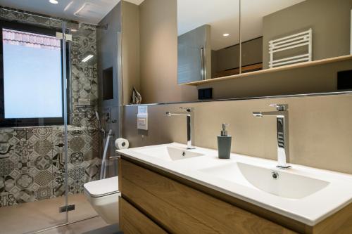 La salle de bains est pourvue de 2 lavabos et de toilettes. dans l'établissement Ocean House Herz, à Timmendorfer Strand