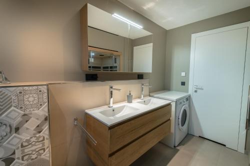 ein Badezimmer mit Waschbecken und Waschmaschine in der Unterkunft Ocean House Garten Eden mit Whirlpool in Timmendorfer Strand