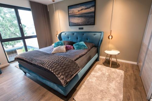 um quarto com uma cama azul com almofadas em Ocean House Traum em Timmendorfer Strand